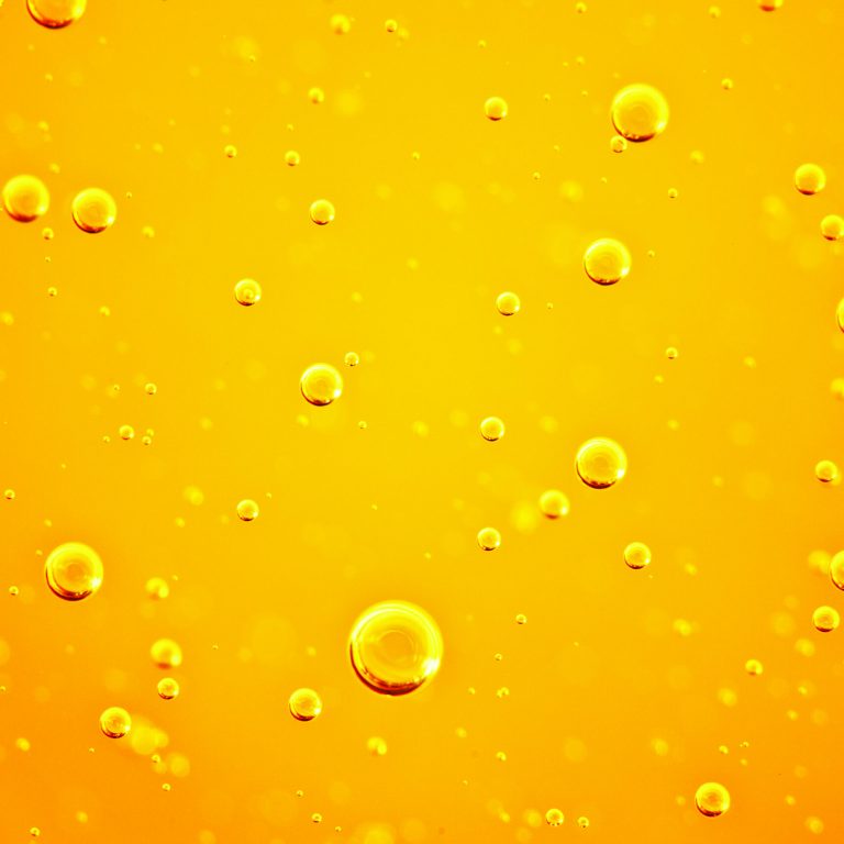 Oil,Background.,Golden,Liquid,With,Air,Bubbles,On,White,Background